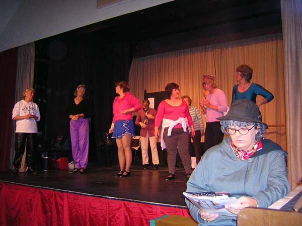 The class with its teacher Mavis (Karen Venn) and accompanist Mrs Fraser (Julie Kingston)